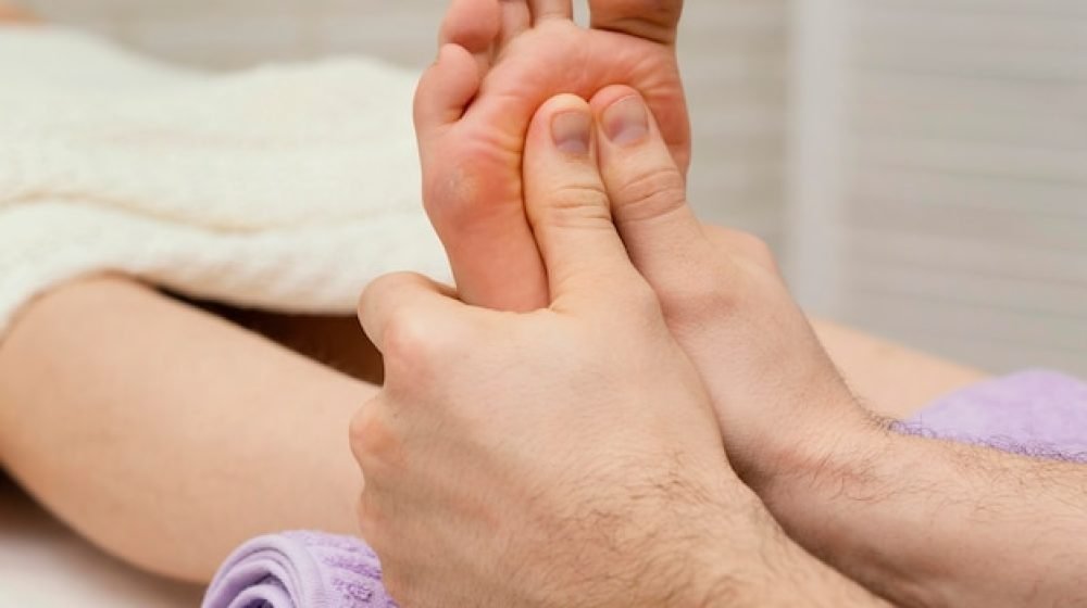 close-up-hands-massaging-sole_23-2148882219